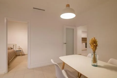 Side view of dining table with white chairs placed between bedroom door and.. Foto stock