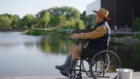 Side view of the disabled asian man wearing hat and special fishing clothes Stock Footage 220053883