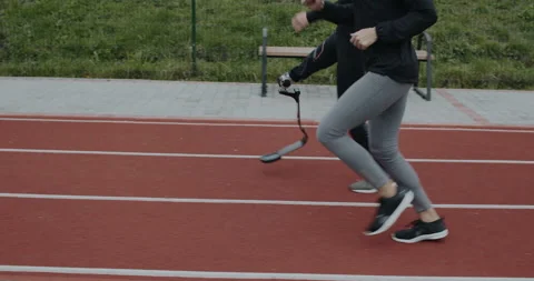 Side view of disabled man and sports woman taking position on marks and start Stock Footage 148613015