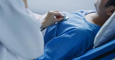 Side view of diverse doctors examining Asian female patient in bed in ward .. Stock-Fotos