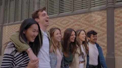Side view of diverse group of joyful generation z friends strolling embracing on Stock Footage 276758272