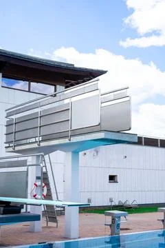 Side view of the diving board in an outdoor swimming pool against the sky Stock Photos