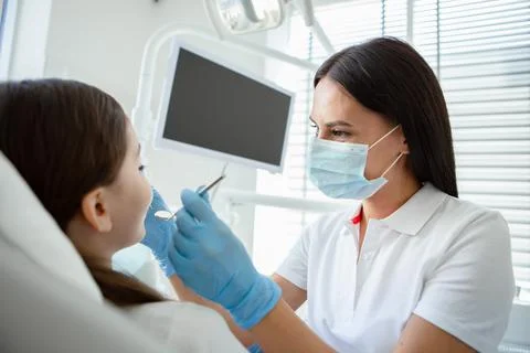 Side view of Doctor treating small patient teeth in modern dental clinic Stock Photos