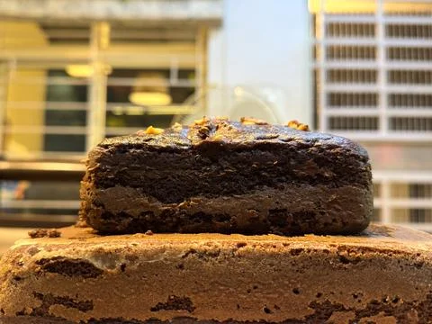 Side view of double layered chocolate banana walnut cake kept in a tray Stock Photos