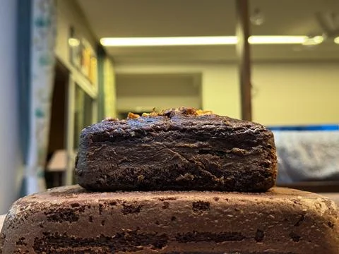 Side view of double layered chocolate banana walnut cake kept in a tray Stock Photos