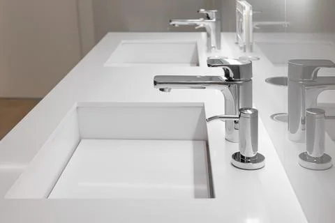Side view of double white sink with large and small taps for filtering running Stock Photos