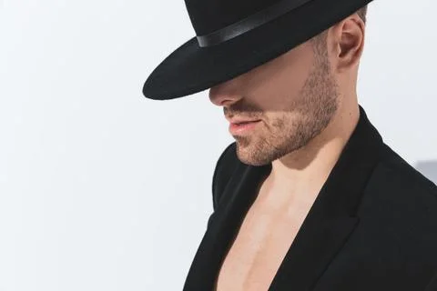 Side view of dramatic cool guy in jacket looking down and covering face Stock Photos