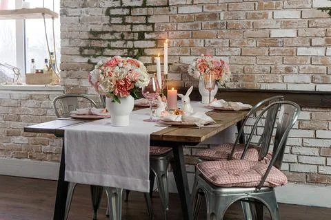 Side view of dreamy cute table decor with glasses flowers and lit candles. We Stock Photos