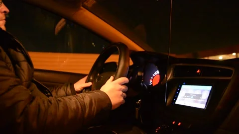 Side view of driver, steering wheel and dashboard in the car while driving at ni Stockbeeldmateriaal 147948206