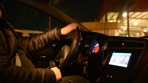 Side view of driver, steering wheel and dashboard in the car while driving at ni Видео 147948209