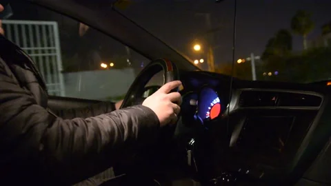 Side view of driver, steering wheel and dashboard in the car while driving at ni Stockbeeldmateriaal 147948220
