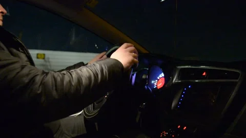 Side view of driver, steering wheel and dashboard in the car while driving at ni Stockbeeldmateriaal 147948223