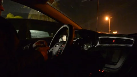Side view of driver, steering wheel and dashboard in the car while driving at ni Stockbeeldmateriaal 147948224