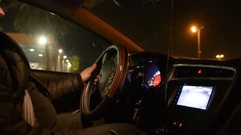 Side view of driver, steering wheel and dashboard in the car while driving at ni Stockbeeldmateriaal 147948246