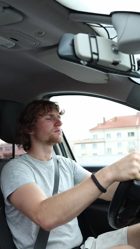 Side view of a driver watching the road while navigating a car through the city Stock Footage 342923696