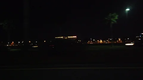 Side View Driving At Night Past Buildings With Palm Trees Hotels On Highway Stock Footage 127843011