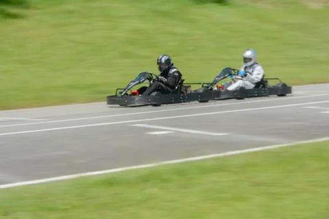 Side view of dynamic image of two competitive, moving fast, go-karts. Stock Photos