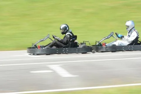 Side view of dynamic image of two competitive, moving fast, go-karts. Stock Photos