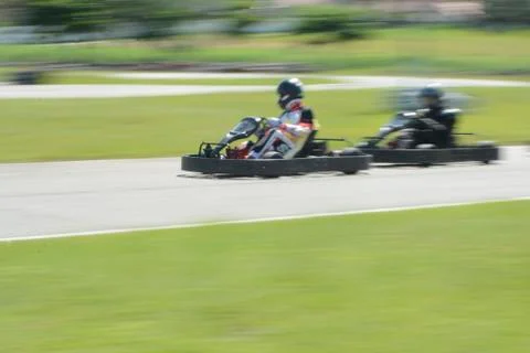 Side view of dynamic image of two competitive, moving fast, go-karts. Stock Photos