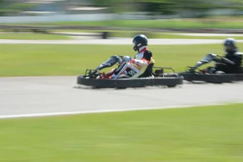 Side view of dynamic image of two competitive, moving fast, go-karts. Stock Photos
