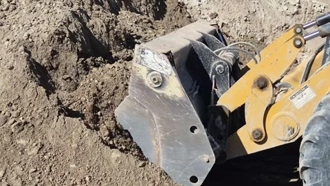 Side View of Earthmover Digging and Lifting Soil While Moving Backward Stock Footage 332729144