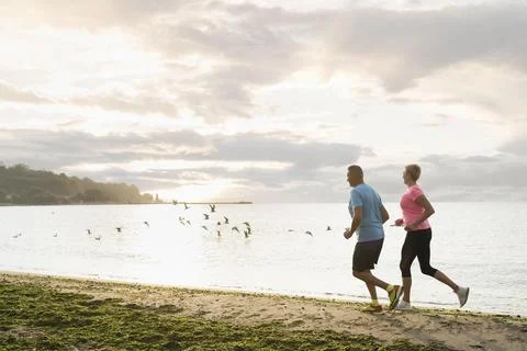 Side view elder couple jogging beach Beautiful photo Stock Photos