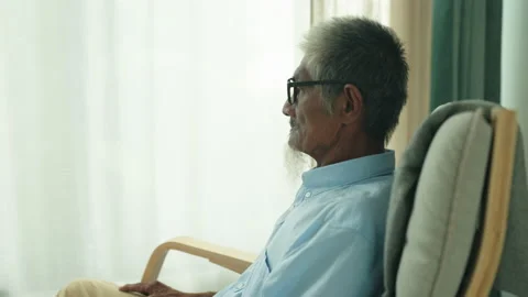 Side view. Elderly asian man wearing glasses sitting on chair Stock Footage 238919952