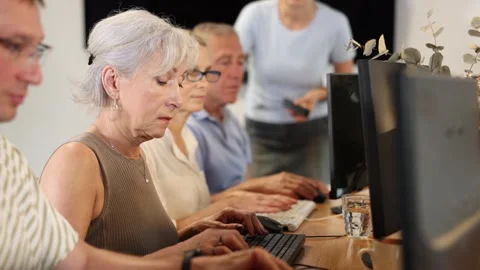 Side view of elderly people while studying in computer class in nursing home Stock Footage 276948594