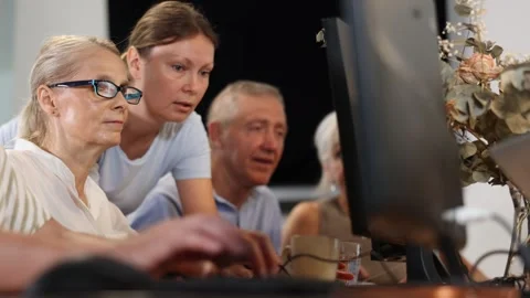 Side view of elderly people while studying in computer class in nursing home Stock Footage 306704071