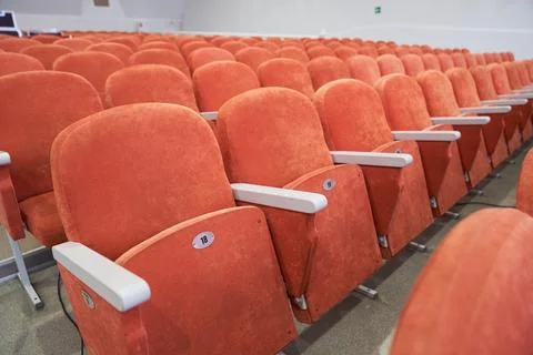 Side view of empty cinema hall with orange seats with copy space. Seats with Stock Photos