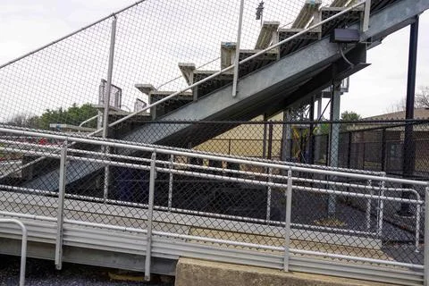 Side view of empty outdoor High School stadium bleachers seats steps Stock Photos
