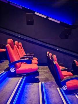 Side View of Empty Red Cinema Seats Through Staircase with Blue Lighting Stock Photos
