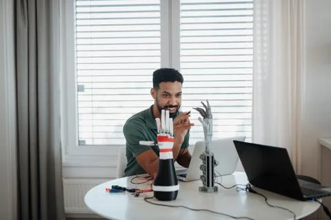 Side view of engineer building and programming a robotic arm at home. Stock Photos