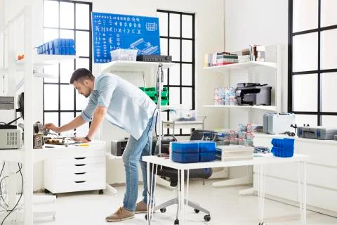 Side view of engineer working at table in electronic laboratory Stock Photos