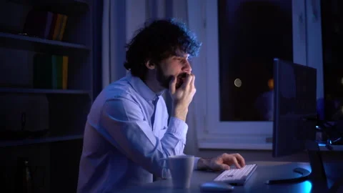Side view of exhausted young man yawning during working on computer at late Video stock 146417287