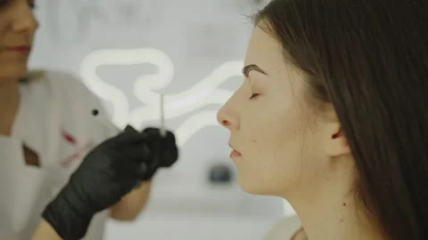Side view of eyebrow microblading procedure in progress Video stock 331826602