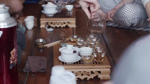 Side view of faceless man brewing pouring hot tea into glass bowls indoors slow Stock Footage 139049268
