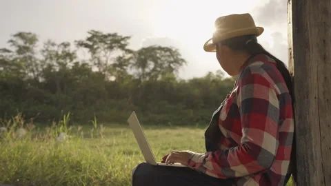 Side view of farmer woman using laptop computer for check goat farm Stock Footage 157200151