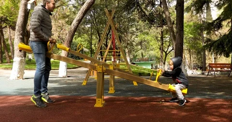 Side view of father and son having fun on swing 動画素材 106985287
