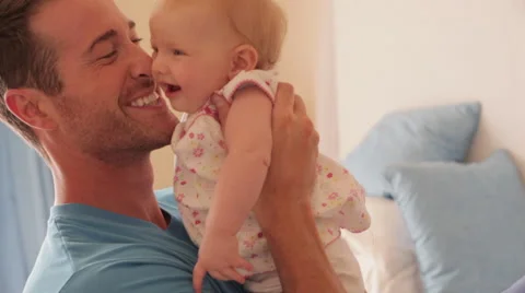 Side view of father on bed with baby daughter. Stock Footage 43668025