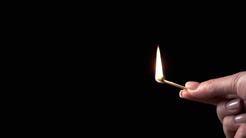Side View, Female Hand Holding Burning Match in Dark Room Stock Footage 312013752