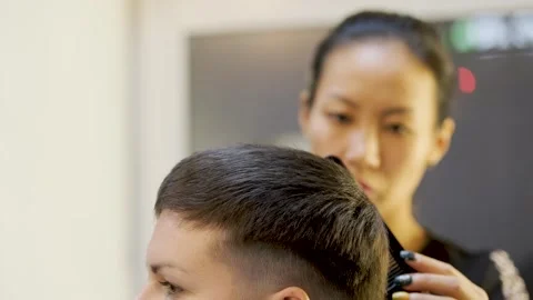 Side view of female head with short black hair. Asian stylist shapes a hairstyle 库存影片 258050851