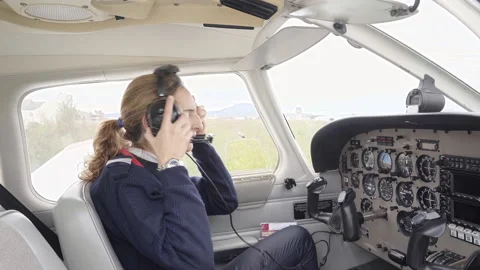 Side view of a female pilot in the cockpit of an airplane. 库存影片 146375603