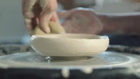 Side view of female potter uses sponge to make ceramic pot on the twisted Stock Footage 143616680