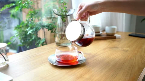 Side view of a female pouring tea into tea cup. Stock Footage 134260790