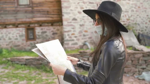 Side view of female tourist exploring map. New normal tourist with face mask in Stock Footage 144102299