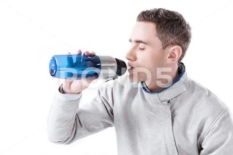 Side view of fencer drinking water from bottle on white Stock Photos