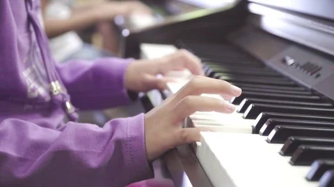 Side view of fingers of Child learning to play the piano. Stock Footage 83310289