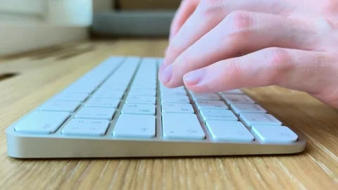 Side view of fingers pressing keys on a keyboard. Hands typing near a woode.. Stock Footage 340284050
