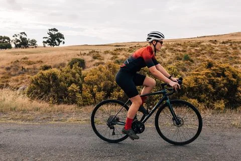 Side view of fit and determined sportswoman cycling road bike Stock Photos